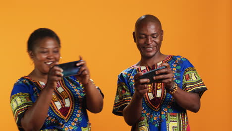 african american couple playing mobile videogames on camera