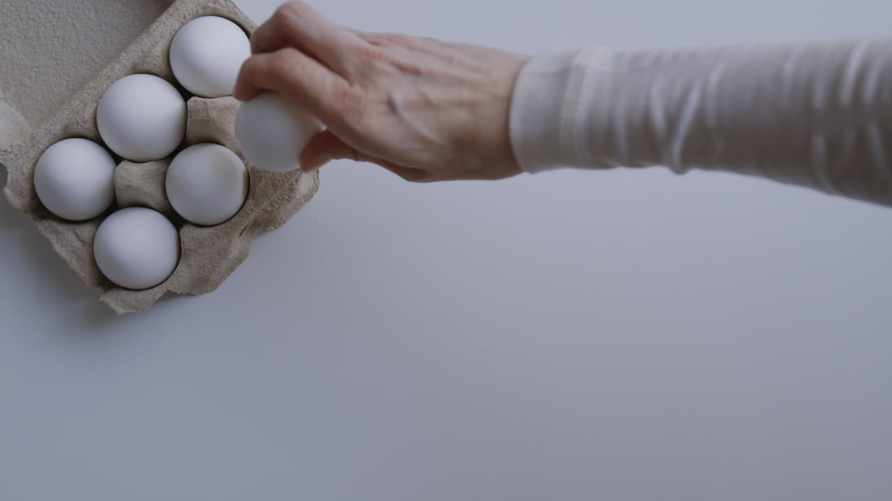 Hand taking an egg from a carton