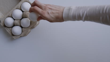 hand taking an egg from a carton