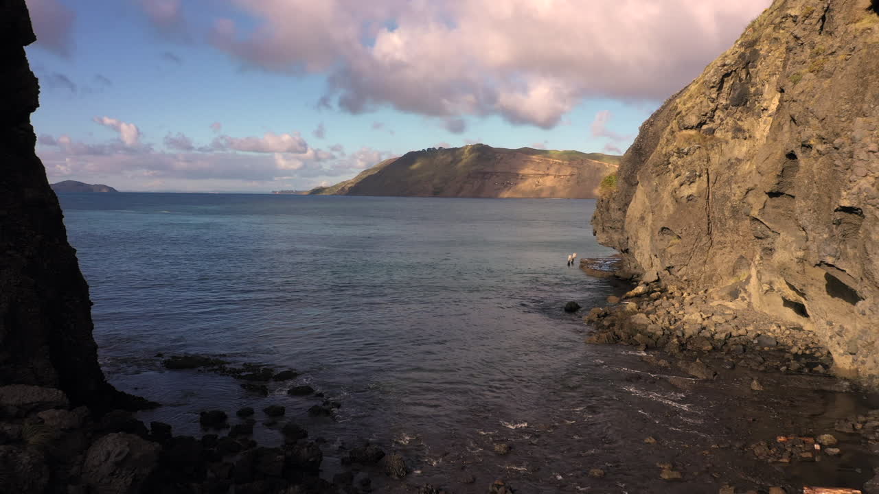 vuelo hacia atrás desde las cabezas de whatipu y manukau, auckland, nueva zelanda, toma aérea