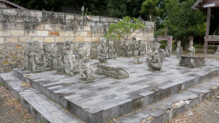Antica scacchiera in pietra con statue culturali in Indonesia, all'aperto, di giorno