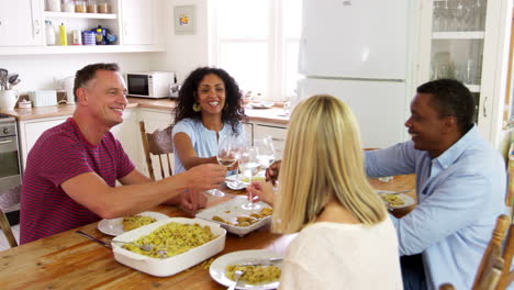 pareja madura entreteniendo a amigos en una fiesta de cena