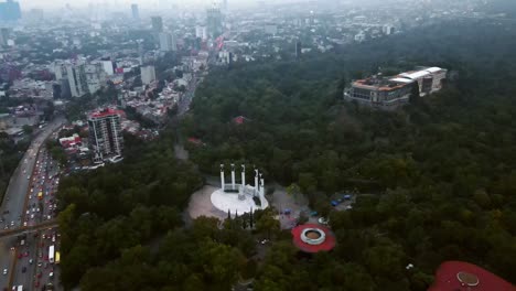 Aerial-orbit-of-the-Altar-a-la-Patria-and-the-castle-in-the-Chapultepec-forest-in-the-Mexican-capital-on-a-foggy-winter-day