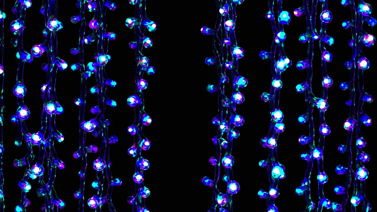 Close-up video of hanging blue LED string lights against a black background, creating a vibrant