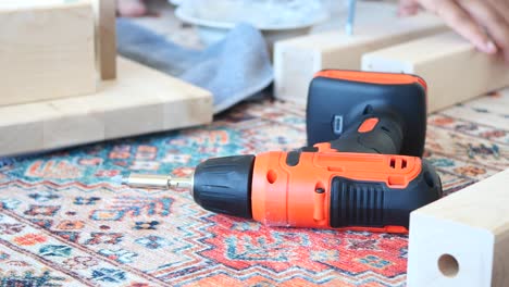 primer plano de un taladro eléctrico y piezas de madera