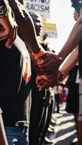 people holding hands in unity at an anti-racism protest