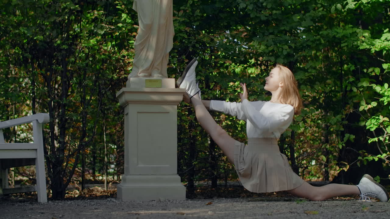 Woman Stretching in a Park near a Statue