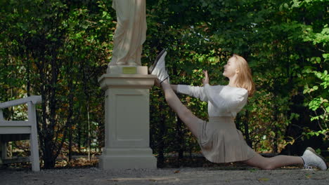 woman stretching in a park near a statue