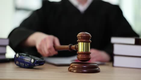 judge with gavel and overturned toy car in court