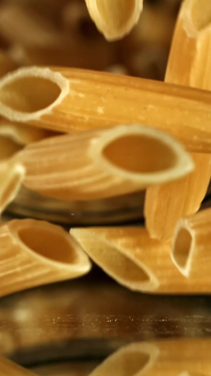 Primo piano di penne secche che cadono al rallentatore
