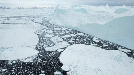 Glacier-breaking-into-pieces-due-to-global-warming-problem,-aerial-drone-view