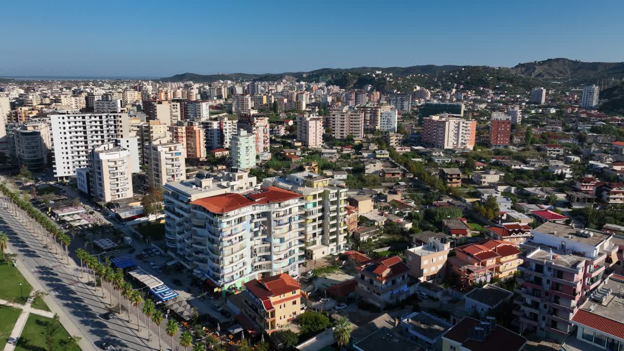 Aerial: Vlore cityscape during the day with blue sky in Vlore County, Albania, orbit drone shot