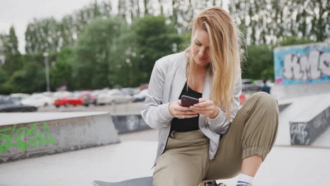 young woman using mobile phone in urban skate park