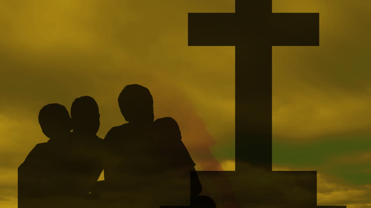 Family standing near large cross at sunset, creating animation-like silhouette