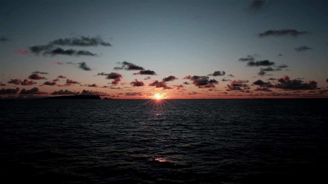 Sun on the horizon over the ocean as seen from a boat