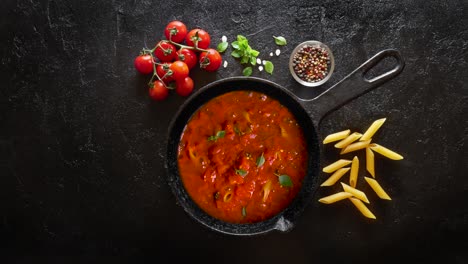 cinemagraph loop. cocinar pasta penne con salsa de tomate y albahaca en una sartén de hierro fundido.