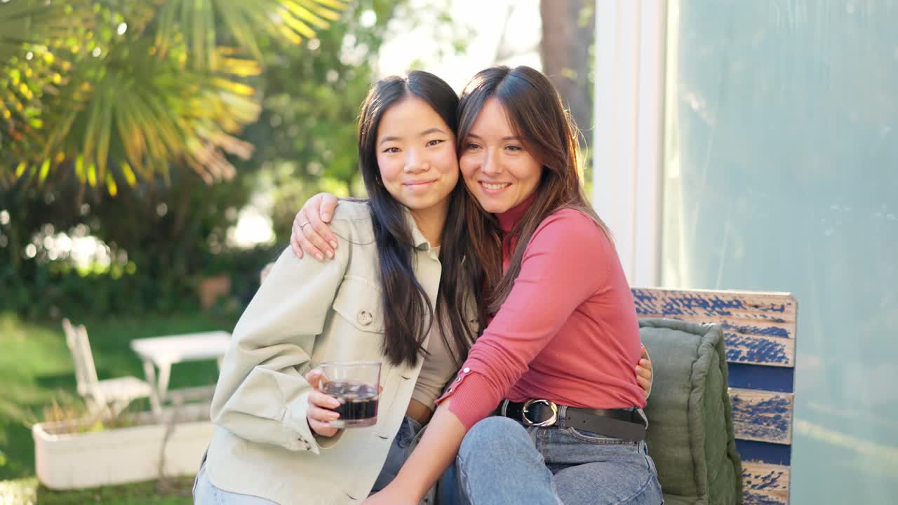Best friends smiling at camera while chilling in the garden