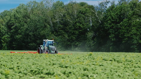 tractor tira del mecanismo agrícola de campo para desmalezar plantas