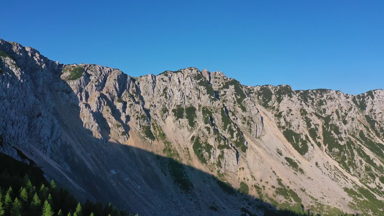 vista aérea de la cresta de la montaña en austria con pedestal hasta la línea de árboles forestales
