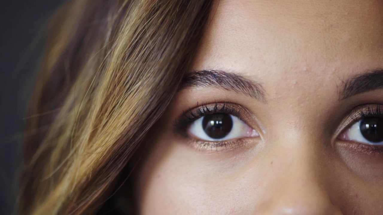 Close-up of Young Woman Looking Down and Then Into Camera