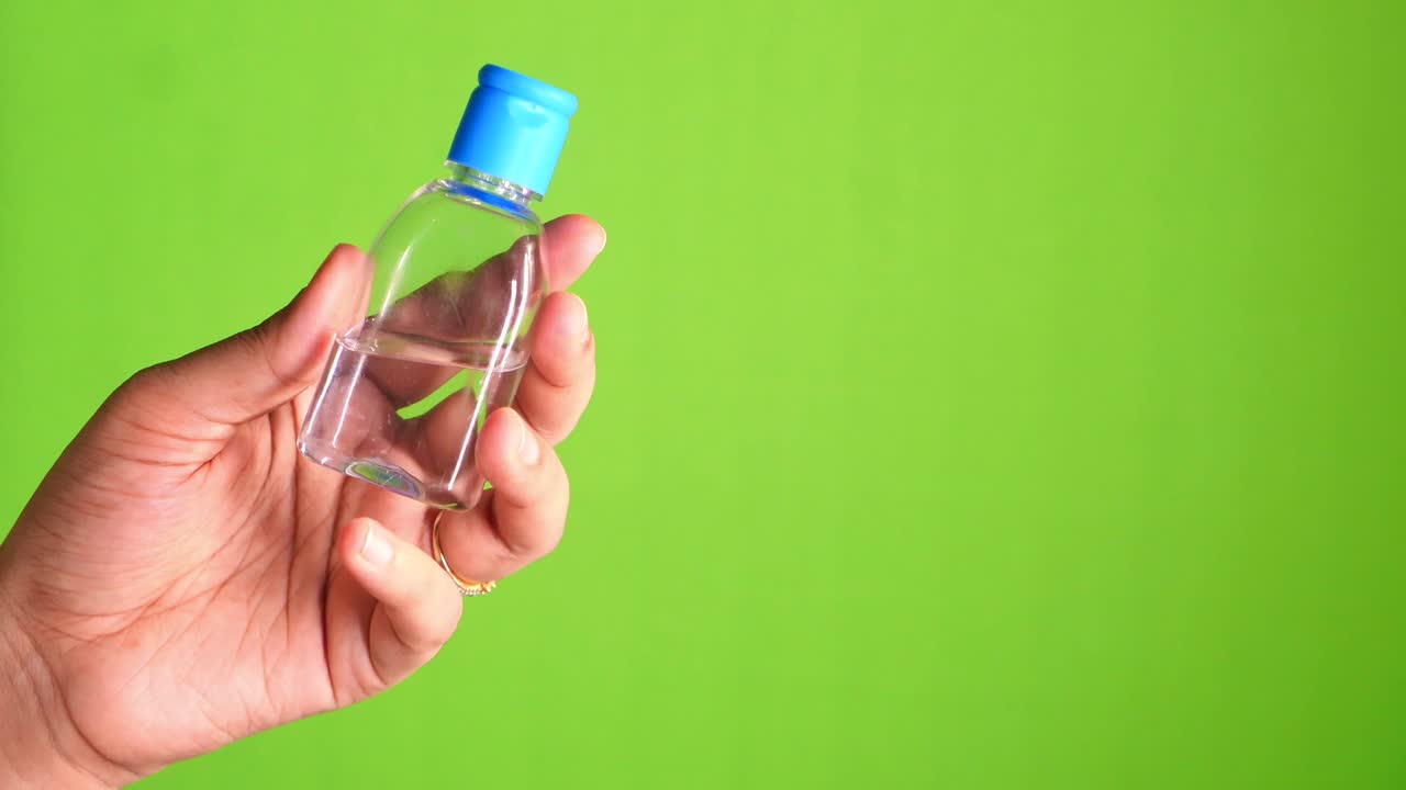 mano con una pequeña botella de desinfectante para manos