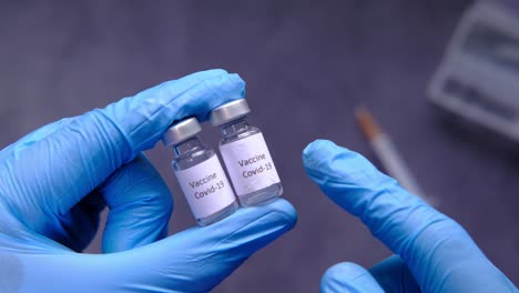 covid-19 vaccine vials being held