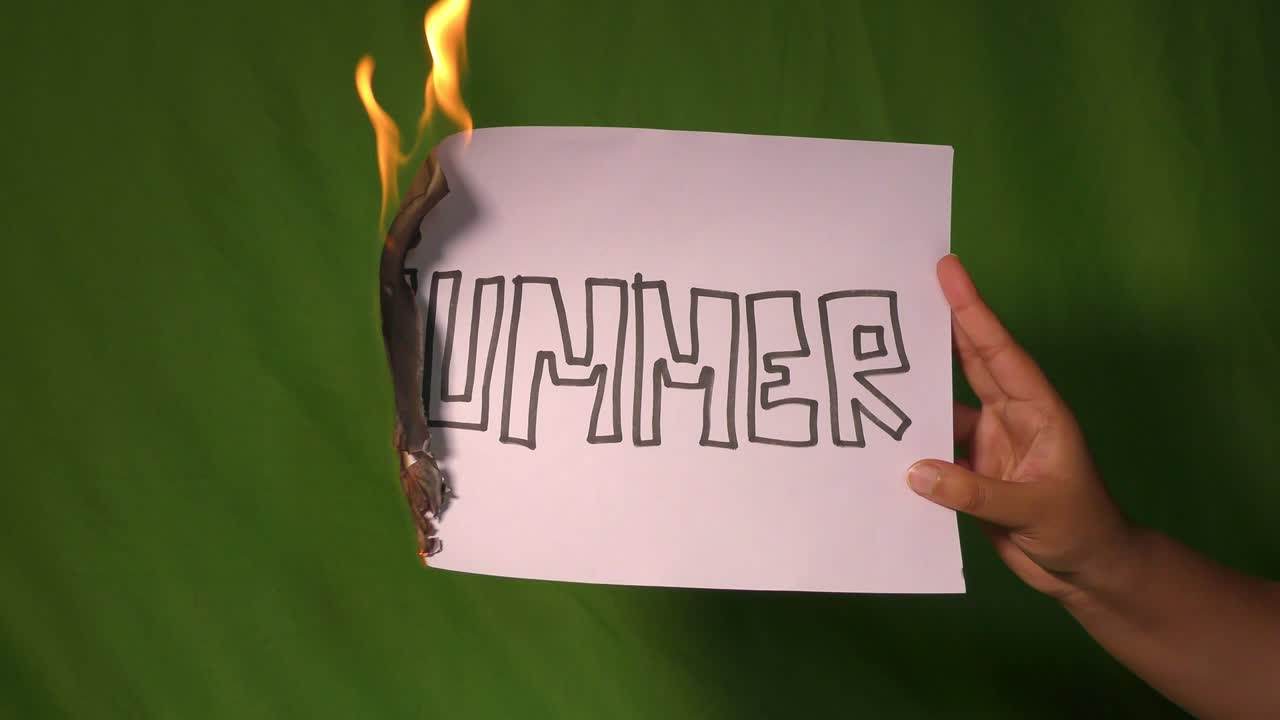 한 손은 여름 분할 텍스트 단어가 새겨진 불타는 종이를 들고 있습니다.