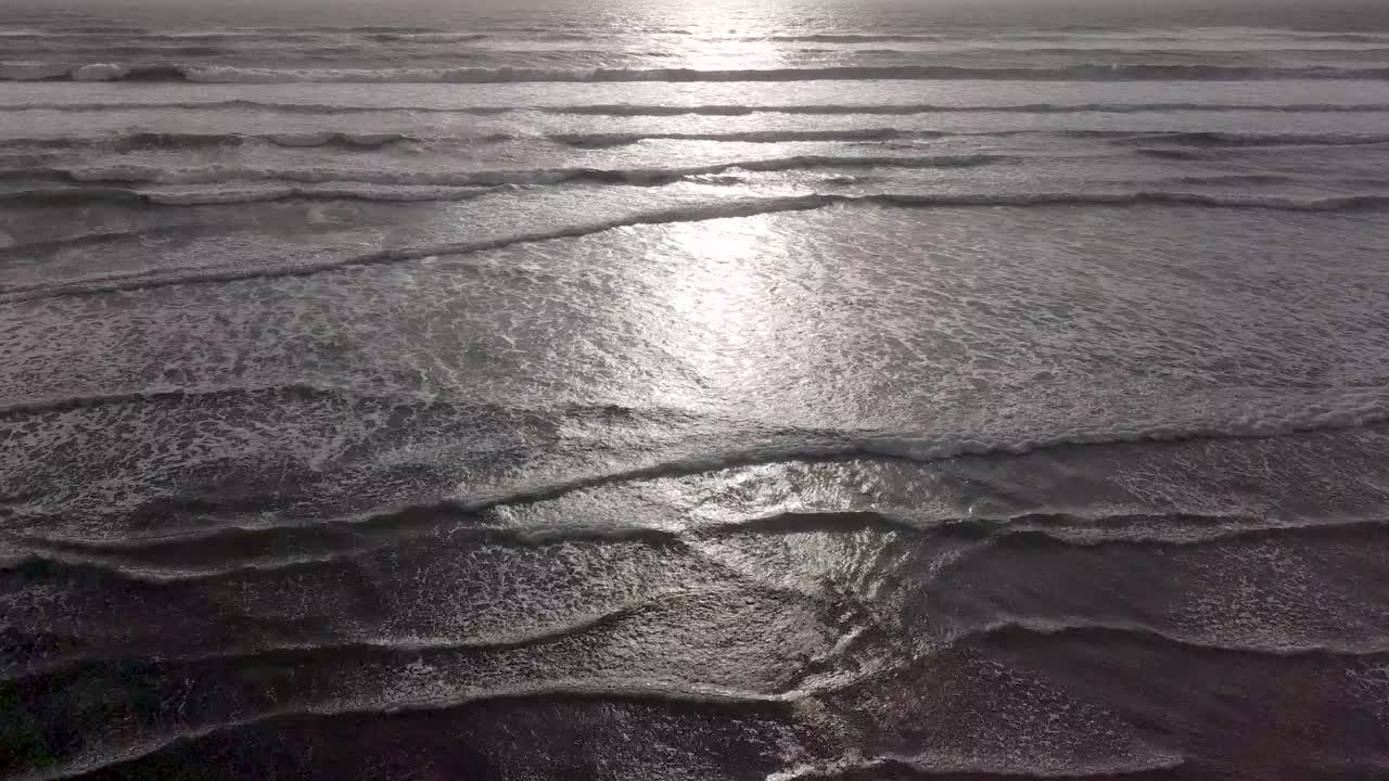 Aerial View of Ocean Waves with Sunlight Reflection
