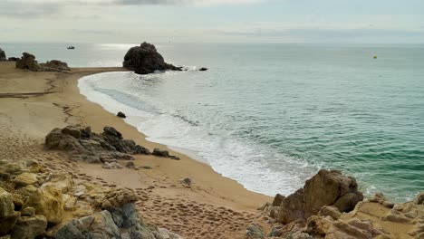 Mediterranean-beach-without-people-at-sunrise-turquoise-blue-calm-water-Barcelona-coast-Maresme-Costa-Brava-Spain-European-tourism