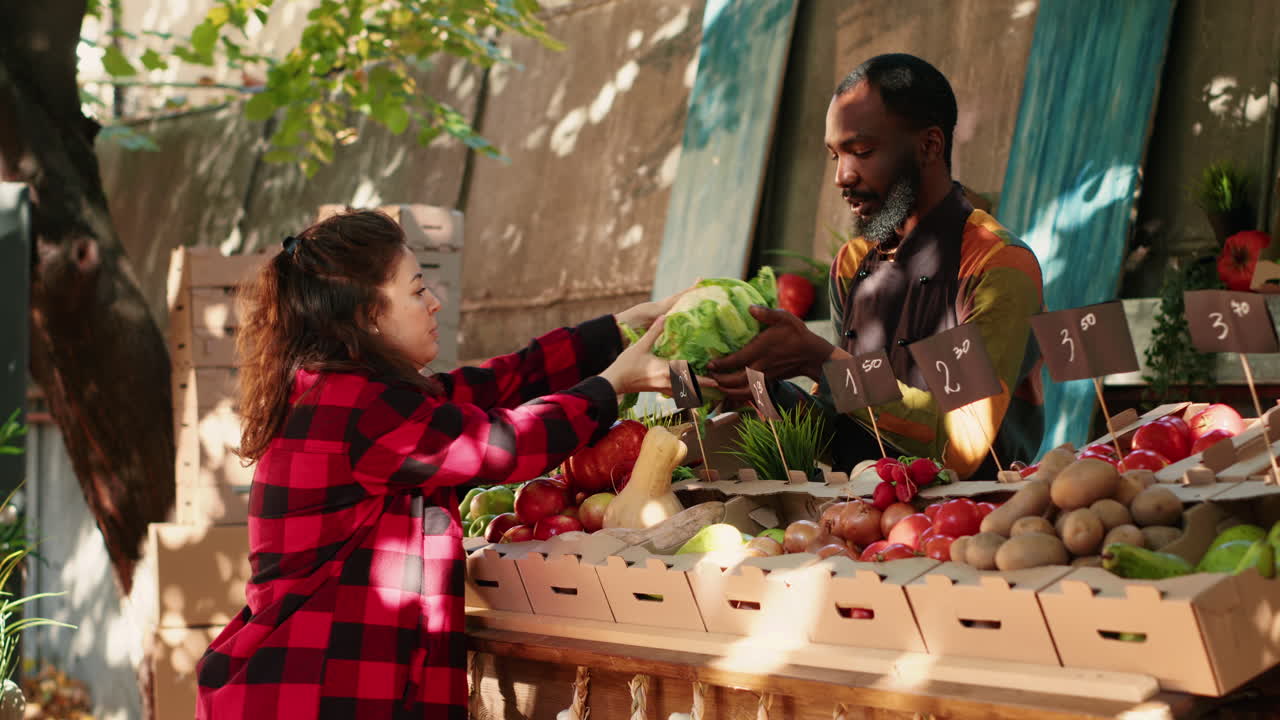 People buying vegetables at a market stall