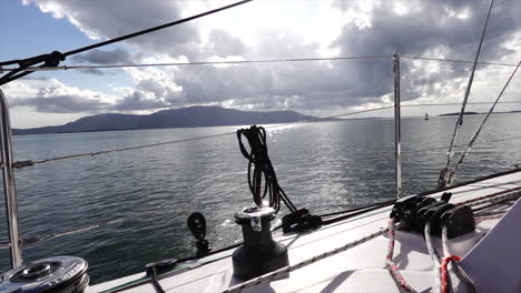 view from a sailboat as god rays pierce the clouds over the san juan islands on a calm day
