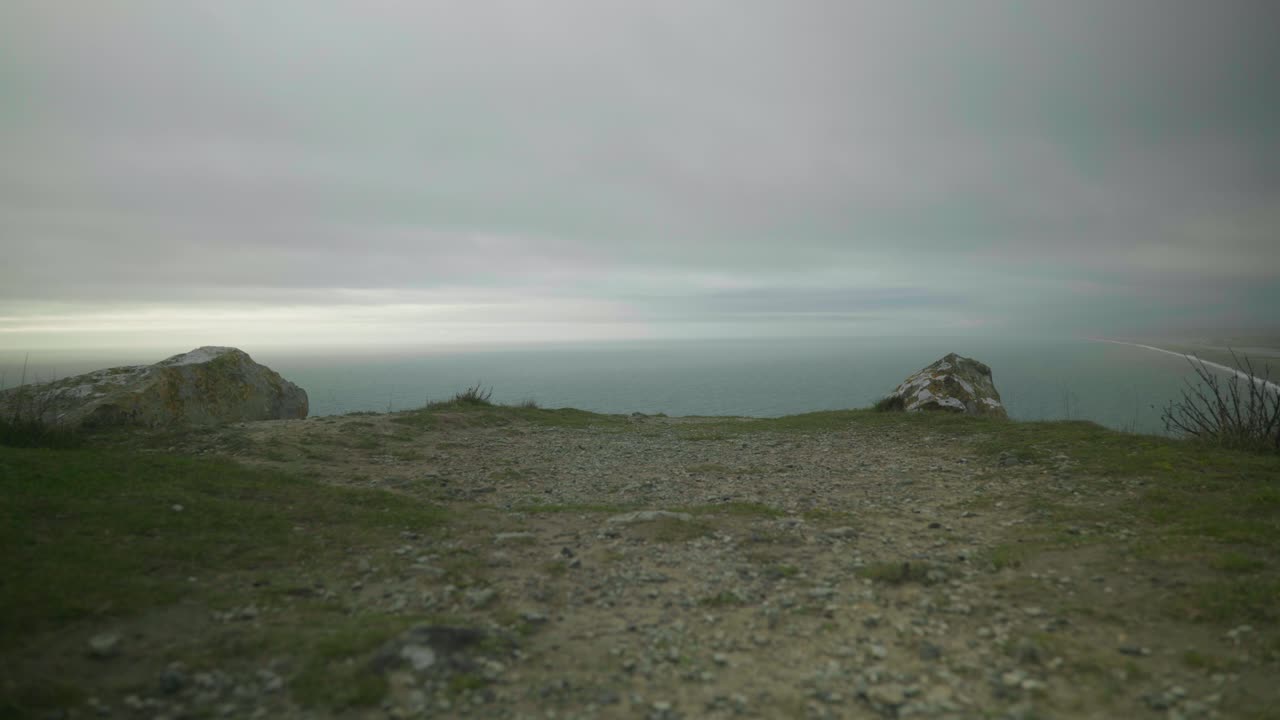 4K Cinematic landscape shot of the ocean on the edge of a cliff on Portland, Dorset on a cloudy day
