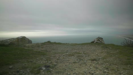 4K Cinematic landscape shot of the ocean on the edge of a cliff on Portland, Dorset on a cloudy day