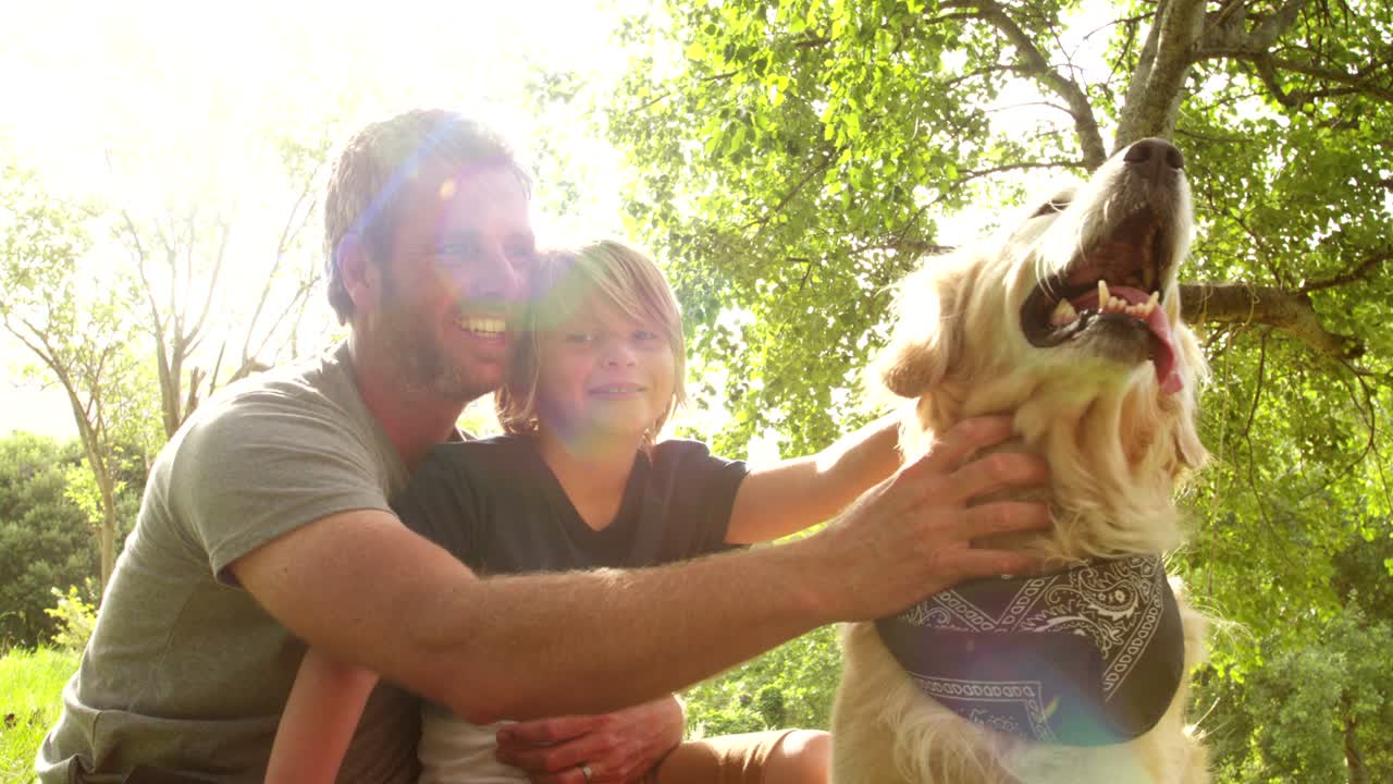 아빠는 귀여운 아들과 그들의 개와 함께 밖에서 놀고 있습니다.