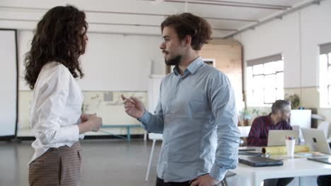 focused young woman meeting with confident colleague in eyeglasses