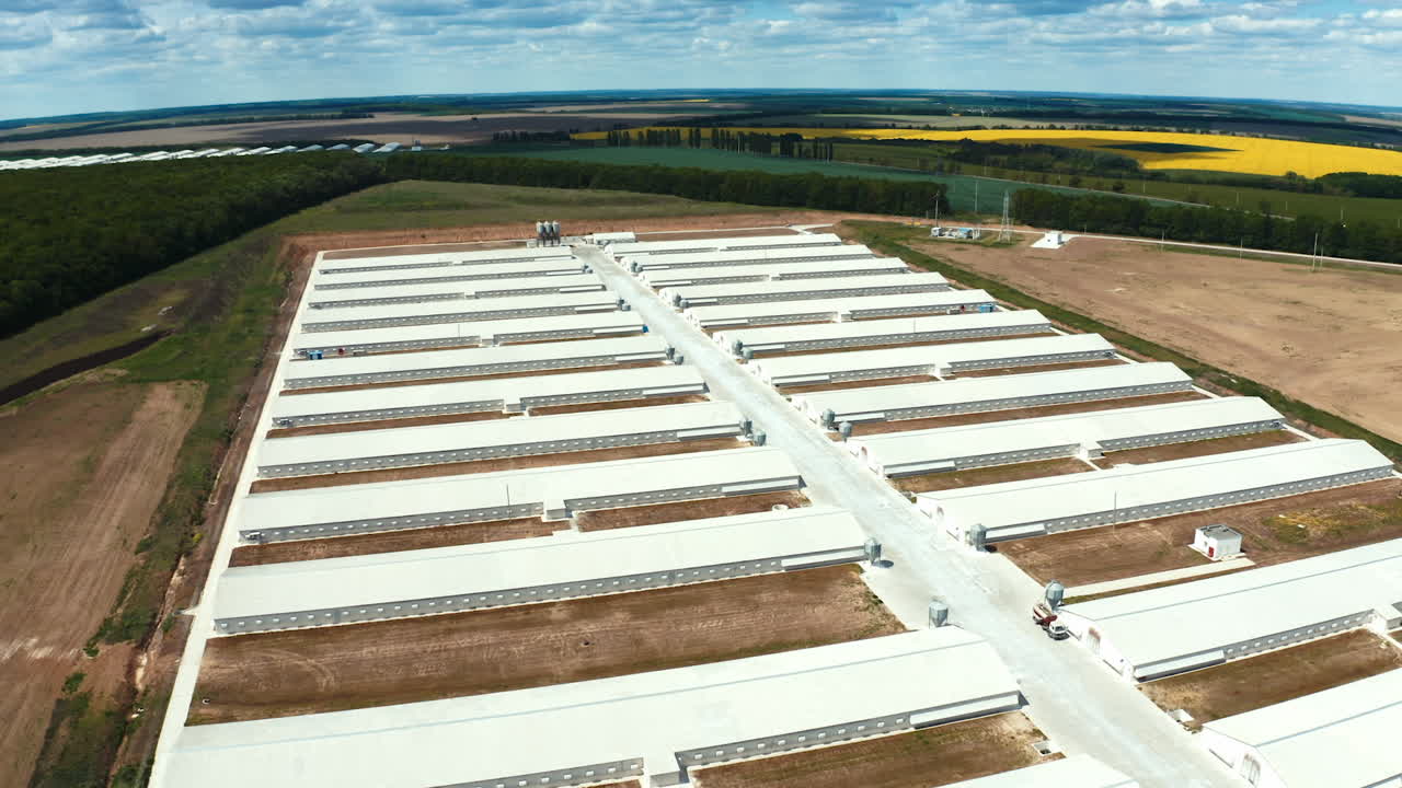 Innovative complex among nature. White roofs of a modern production plant on the field. Exterior of manufacturing. Aerial view.
