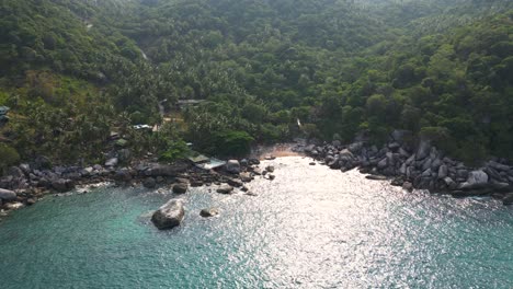 Stunning-drone-shot-over-beautiful-ocean-bay-with-sparkling-water-reflections