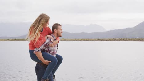 caucasian couple having a good time on a trip to the mountains, smiling, the man holding the woman