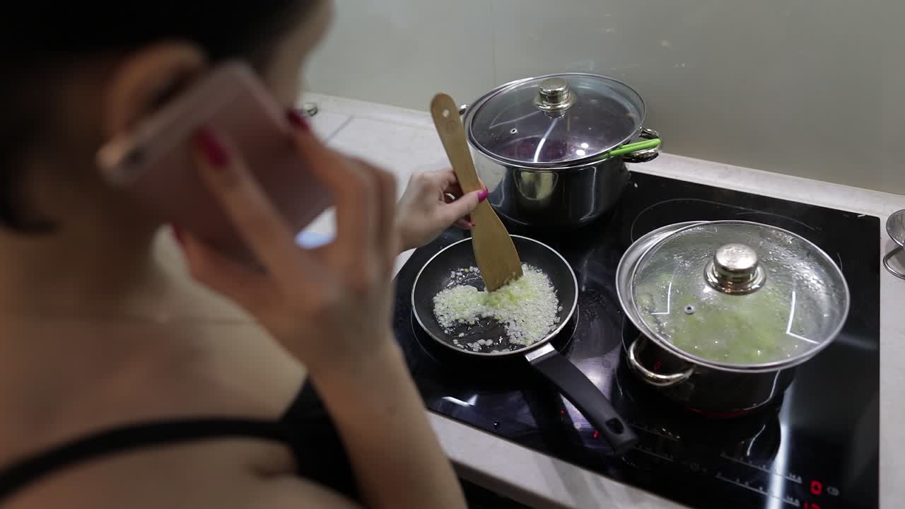 hermosa mujer caucásica hablando por teléfono mientras cocina