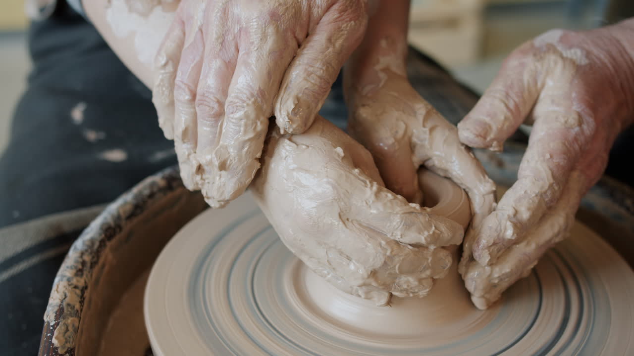 Child and adult learning pottery together