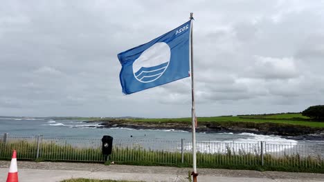 blue flag on a cloudy day at a certified beach