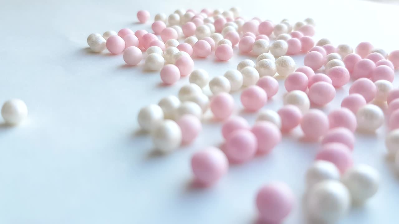 색 배경에 색과 분홍색 공이나 메이크업 파우더 구슬을 굴리기, 최소한의 아이디어 개념, 4k 비디오