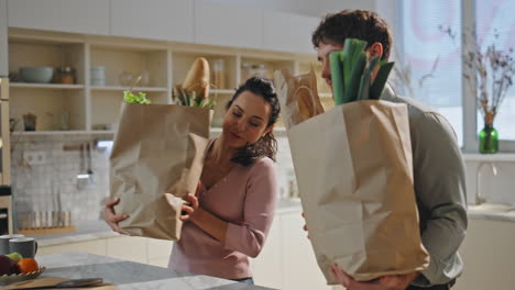 couple sorting purchased products standing at cozy kitchen countertop close up.