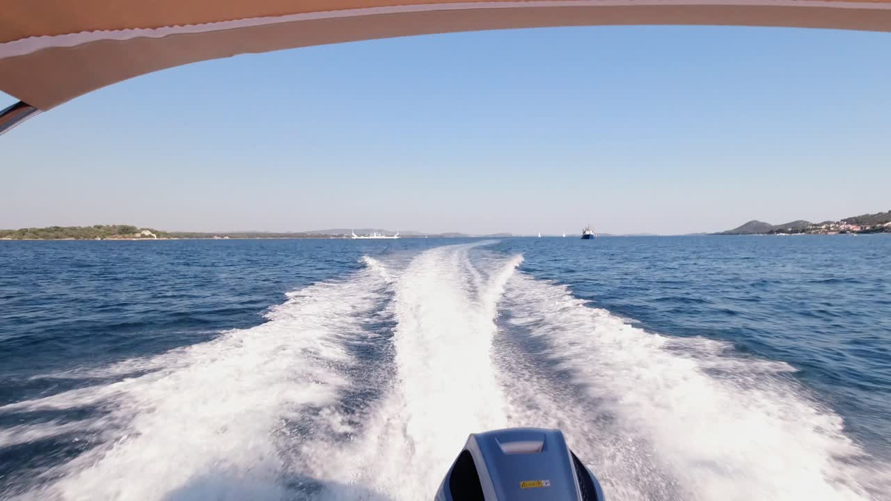 캐노피와 아웃보드 모터가 장착된 보트가 파란색 아드리아 해에서 크게 깨어납니다.