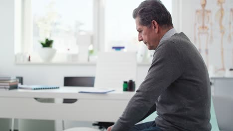 Handheld-view-of-worried-senior-man-in-doctor’s-office