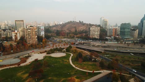 Vista-Aérea-Del-Cerro-San-Luis-En-La-Ciudad-De-Santiago-De-Chile-Con-Tráfico-Diurno-En-La-Carretera