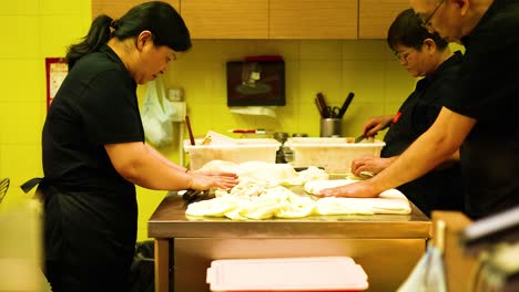 chefs preparing food together in a kitchen