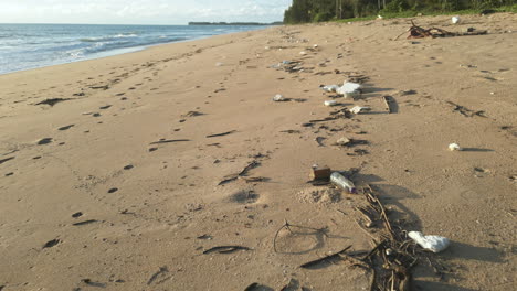 Rubbish-washed-out-on-coastline-of-Khao-Lak,-dolly-backward-view