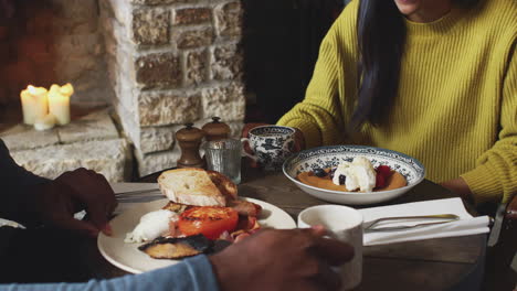 un primer plano de una camarera que trabaja en un pub inglés tradicional sirviendo desayuno a los huéspedes