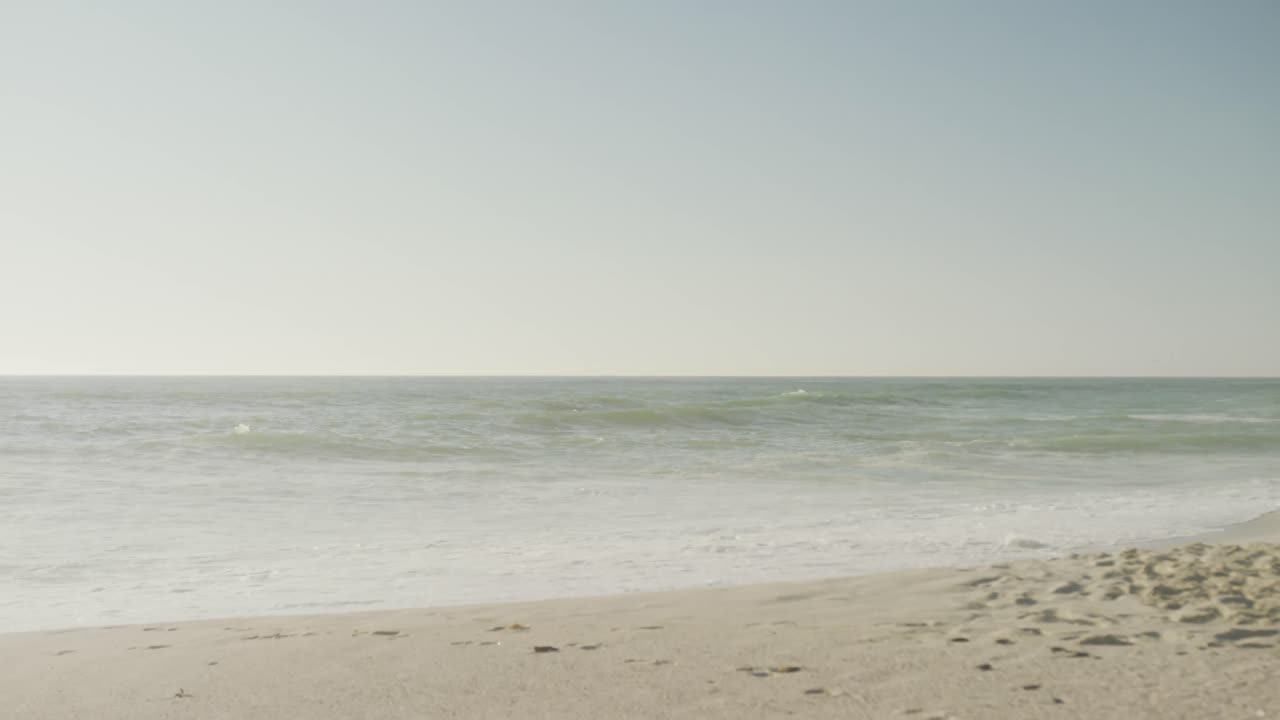 파란 하늘과 바다는 비어 있고  ⁇ 은 해변에 파도가 있습니다.